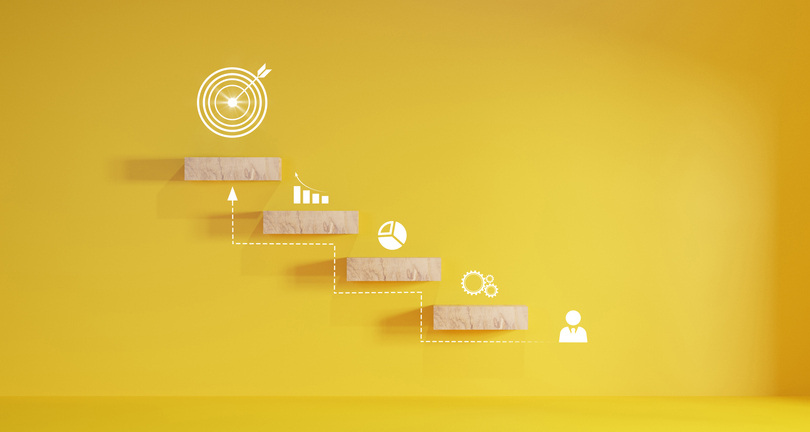  Cube block staircase moving step growing up to target on yellow background. Depicting Success.